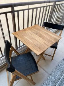 een houten tafel en een blauwe stoel op een balkon bij Apartamento inteiro em Sky Pauliceia in Sao Paulo