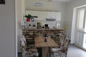 a kitchen with a wooden table and chairs with wine glasses at Apartments with a parking space Mocici, Dubrovnik - 12856 in Čilipi