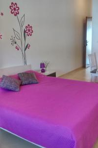 a large bed with a pink bedspread in a room at Apartments with WiFi Fazana - 12862 in Marana