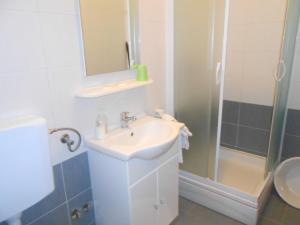 a bathroom with a sink and a mirror and a shower at Apartments with WiFi Fazana - 12862 in Marana