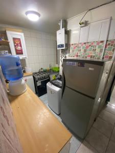 a kitchen with a counter and a refrigerator at Habitaciones en pensión en centro de Iquique in Iquique