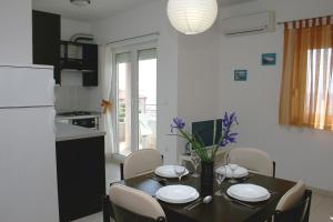 - une cuisine et une salle à manger avec une table et des chaises dans l'établissement Apartments with a parking space Bilo, Primosten - 12870, à Primošten