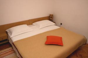 Una cama con una almohada roja. en Apartment Bilo 12868b en Primošten