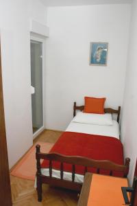 Un dormitorio con una cama con una manta roja. en Apartment Bilo 12868b en Primošten
