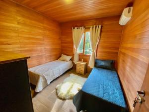 Un pat sau paturi într-o cameră la CHALÉ MONTANHÊS ALPES