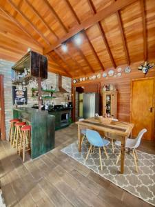 a kitchen with a wooden ceiling and a wooden table and chairs at CHALÉ MONTANHÊS ALPES in São Francisco de Paula