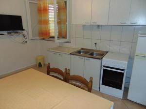 uma cozinha com uma mesa, um fogão e um lavatório em Apartments and rooms by the sea Sucuraj, Hvar - 12887 em Sućuraj