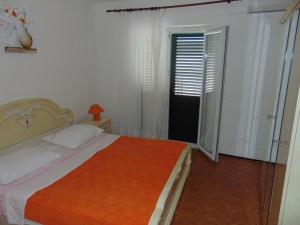 a bedroom with a bed with an orange blanket at Apartments and rooms by the sea Sucuraj, Hvar - 12887 in Sućuraj