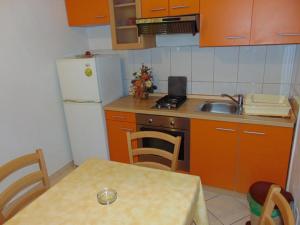 a kitchen with a table and a sink and a refrigerator at Apartments and rooms by the sea Sucuraj, Hvar - 12887 in Sućuraj +9 photos