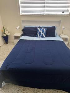 a blue bed with blue pillows in a bedroom at Lovely 1-Bedroom Apartment in Miami