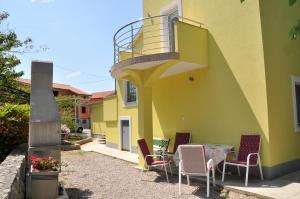 einen Tisch und Stühle außerhalb eines Gebäudes in der Unterkunft Apartments with a parking space Omisalj, Krk - 12793 in Omišalj