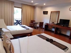 een hotelkamer met 2 bedden en een bureau bij Sailom Resort Bangsaphan in Bang Saphan