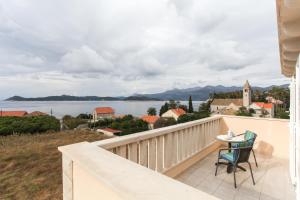 a balcony with a table and chairs and a view of the water at Studio Lopud 12910b in Lopud
