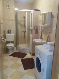 a bathroom with a shower toilet and a washing machine at Apartments by the sea Seget Vranjica, Trogir - 12915 in Trogir