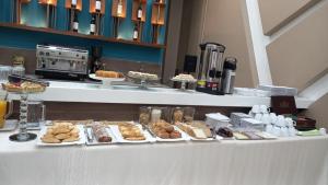 uma linha de buffet com vários produtos de pastelaria sobre a mesa em HOTEL INNOVA em Tarija
