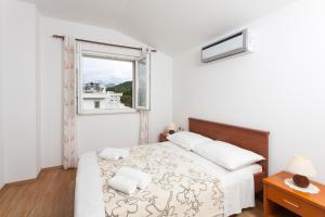 a white bedroom with a bed and a window at Apartments by the sea Lopud, Elafiti - 12910 in Lopud
