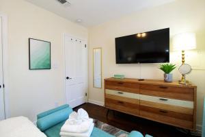 uma sala de estar com uma televisão de ecrã plano na parede em Beachy Bungalow for Family Fun! Walk to beach! em Pensacola