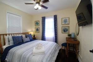 a bedroom with a bed with a hat on it at Beachy Bungalow for Family Fun! Walk to beach! in Pensacola