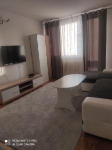 een woonkamer met een witte tafel en een bank bij Grbavica in Sarajevo