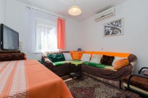 uma sala de estar com um sofá com almofadas coloridas em Apartments with a parking space Novi Vinodolski - 12790 em Novi Vinodolski