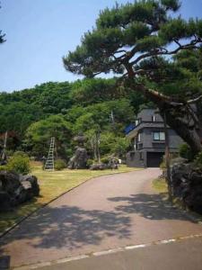 una casa con un albero di fronte a un vialetto di Senougen a Sapporo