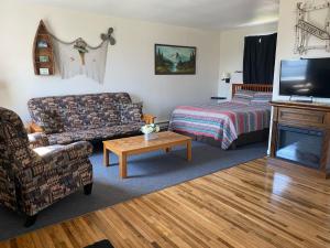 Sala de estar con sofá, cama y TV en Pelican Motel en Pelican Rapids