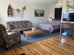 a living room with a couch and a bed and a television at Pelican Motel in Pelican Rapids