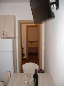 een keuken met een tafel met een fles wijn erop bij Apartments with a parking space Orebic, Peljesac - 12361 in Orebić