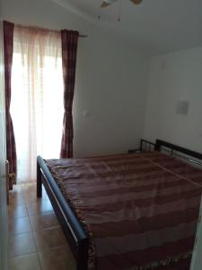 a bedroom with a bed and a window with curtains at Apartments with a parking space Starigrad, Paklenica - 12992 in Starigrad