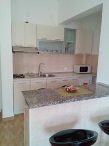 a kitchen with white cabinets and a counter top at Apartments with a parking space Starigrad, Paklenica - 12992 in Starigrad +39 photos