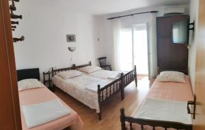 a bedroom with two beds and a television in it at Apartments by the sea Rogoznica - 12995 in Rogoznica