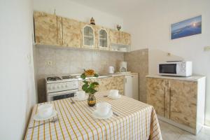 a small kitchen with a table with a table cloth at Apartments by the sea Rogoznica - 12995 in Rogoznica