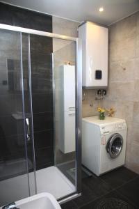 uma casa de banho com um chuveiro e uma máquina de lavar roupa em Seaside holiday house Postira, Brac - 13001 em Postira