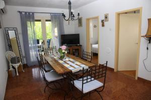 uma sala de jantar com uma mesa de madeira e cadeiras em Seaside holiday house Postira, Brac - 13001 em Postira