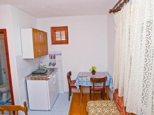 a kitchen with a table and a small kitchen with a table and chairs at Apartments by the sea Brist, Makarska - 12991 in Podaca