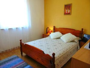 a bedroom with a wooden bed with two pillows on it at Apartments with a parking space Liznjan, Medulin - 13009 in Ližnjan