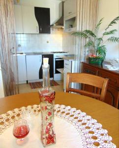 a bottle of wine sitting on a table in a kitchen at Apartments with a parking space Liznjan, Medulin - 13009 in Ližnjan