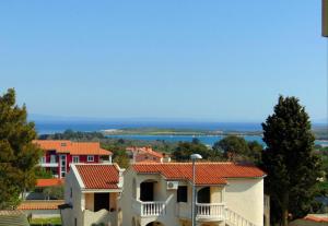 a group of houses with the ocean in the background at Apartments with a parking space Liznjan, Medulin - 13009 in Ližnjan