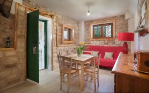 ein Wohnzimmer mit einem Tisch und einer roten Couch in der Unterkunft Secluded fisherman's cottage Cove Tvrdni Dolac, Hvar - 13018 in Gdinj