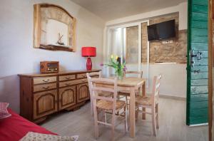 ein Esszimmer mit Tisch und Stühlen und einem Fernseher in der Unterkunft Secluded fisherman's cottage Cove Tvrdni Dolac, Hvar - 13018 in Gdinj