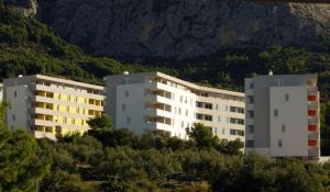 2 bâtiments blancs assis au sommet d'une colline dans l'établissement Apartments with a parking space Makarska - 13028, à Makarska