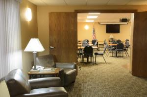 uma sala de espera com cadeiras e um quarto com uma mesa em North Star Hotel Pictured Rocks em Munising