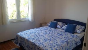 a bedroom with a bed with blue sheets and two windows at Apartments by the sea Hvar - 13041 in Hvar