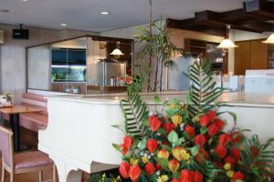 a kitchen with a counter with flowers in it at Business Hotel Furusato in Ibusuki