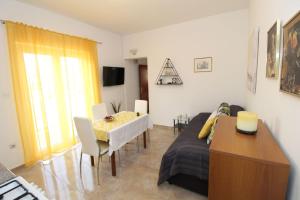 sala de estar con sofá y mesa de comedor en Apartments and rooms with parking space Pag - 13060 en Pag