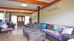 a living room with a couch and chairs and a wall at Getaway On Garden Free Wifi Pet Friendly Outside Only in Inverloch
