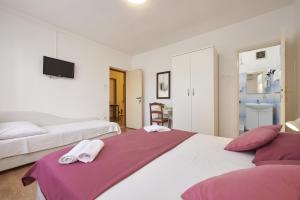 una camera con due letti e una TV a parete di Triple Room Trogir 13102b a Trogir