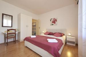 a bedroom with a large bed and a table at Triple Room Trogir 13102b in Trogir