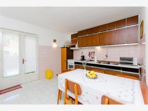 a kitchen with a table with a bowl of fruit on it at Apartments by the sea Hvar - 13109 in Hvar
