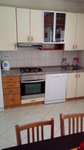 a kitchen with white appliances and wooden cabinets at Seaside holiday house Drace, Peljesac - 13117 in Janjina